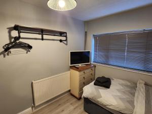 a bedroom with a bed and a television on a dresser at Southernwood - Wantage Road Apt 2 in Didcot