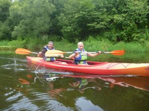 una mujer y un niño en un kayak en el agua en Namelis sodyboje Lazduona, 