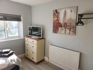 a bedroom with a tv on a dresser and a bed at Southernwood - Wantage Road Apt 2 in Didcot