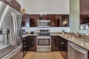a kitchen with stainless steel appliances and wooden cabinets at Broughton Retreat in Savannah