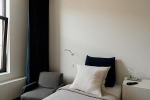 um quarto com uma cama, uma cadeira e uma janela em Befour em Aalst