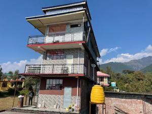 a tall building with a yellow bucket in front of it at BirAlive Cafe & Homes in Bīr
