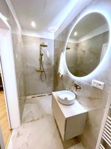 La salle de bains est pourvue d'un lavabo et d'un miroir. dans l'établissement Stylish 3 bedroom apartment in the hearth of city center with history, à Bratislava