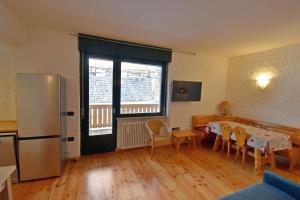 a kitchen with a table and chairs and a refrigerator at SISSI Apartment in Madonna di Campiglio