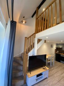 a living room with a staircase and a tv at Ramsey Rooms in Huntingdon