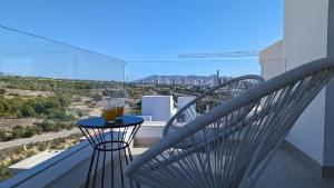 einen Balkon mit 2 Stühlen und einem Tisch mit Getränken darauf in der Unterkunft PANORAMIC pool & mountains house in Finestrat