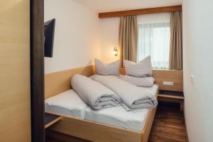a hotel room with a bed with towels on it at Schimpfösslhof in Fiss