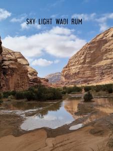 Um rio num desfiladeiro com as palavras "Céu, Luz, Rum" em Sky Light Wadi Rum em Wadi Rum