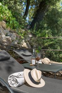 uma mesa com um chapéu e uma garrafa de vinho em Domaine Les Roullets em Oppède