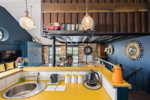 una cocina con encimeras amarillas y un coche rojo en la pared en Pittville Loft Apartment - Central Cheltenham Highly Rated with Free Parking, 