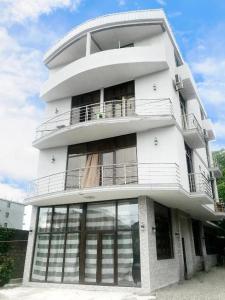 a tall white building with large windows at TikTok house in K'obulet'i