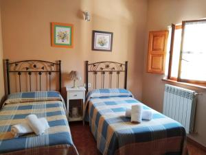 1 dormitorio con 2 camas y toallas. en Pelayo I, en Poo de Cabrales