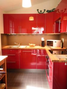 a kitchen with red cabinets and a sink at Le rivage in Biscarrosse-Plage