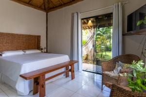 a bedroom with a bed and a sliding glass door at Pousada Villa Mares in Barra Grande