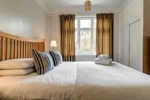 um quarto com uma cama grande com almofadas e uma janela em Lavender House em Oxford