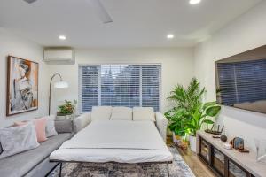 a living room with a couch and a large window at Newly Built Maple Valley Vacation Rental with Patio! in Maple Valley