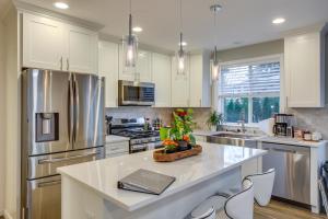 a kitchen with white cabinets and stainless steel appliances at Newly Built Maple Valley Vacation Rental with Patio! in Maple Valley