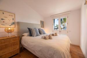 a bedroom with a large white bed with a window at Vivienda Vacacional Pasito Blanco 1 in Pasito Blanco +62 photos