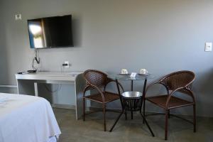 - une table et des chaises dans une chambre avec lavabo dans l'établissement Chalés Casuarinas, à Japaratinga