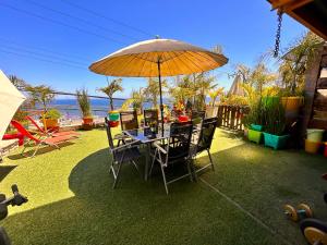 a table and chairs under an umbrella in a yard at Apartamento Pacifico in Viña del Mar