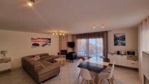 a living room with a couch and a table at Le Cormier - Appartement 6 personnes in Ovronnaz
