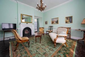 a living room with a couch and a fireplace at Hanwell House, Long Melford in Long Melford