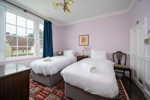 2 camas en una habitación con ventana en Hanwell House, Long Melford en Long Melford