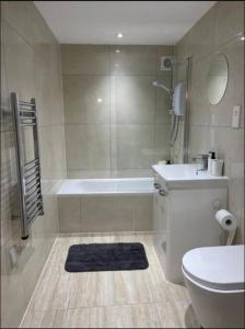 a bathroom with a tub and a toilet and a sink at Aylesbury Apartment 3 with Parking in Buckinghamshire