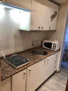 a kitchen with a sink and a microwave on a counter at Amplio con 2 dormitorios y muy equipado LA CANAL in Petrer