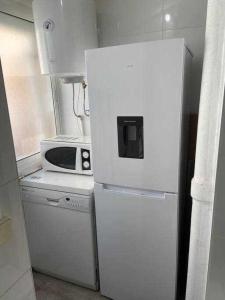 um frigorífico branco numa cozinha com um micro-ondas em Amplio con 2 dormitorios y muy equipado LA CANAL em Petrer