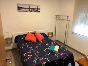1 dormitorio con 1 cama con almohadas rojas y verdes en Amplio con 2 dormitorios y muy equipado LA CANAL, en Petrer