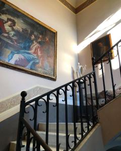 a stairway with a painting on the wall and a painting at Palazzo Mazziotti in Celso