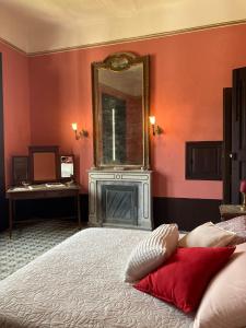 a bedroom with a bed with a mirror and a fireplace at Palazzo Mazziotti in Celso