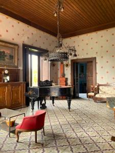 a living room with a piano and a chandelier at Palazzo Mazziotti in Celso
