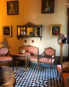 sala de estar con sofás, mesa y retratos en Palazzo Mazziotti en Celso