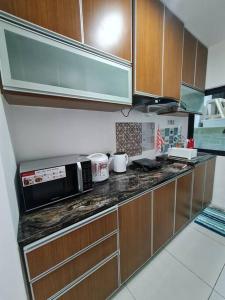 eine Küche mit einer Arbeitsplatte und einer Mikrowelle in der Unterkunft V' BROS Deloft 2 Emporium Kuching in Kuching