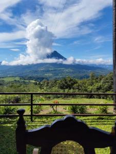 a view of a mountain from a bench at Encanto Arenal lodge in Fortuna