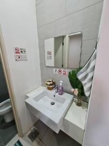 y baño con lavabo blanco y espejo. en V' BROS Deloft 2 Emporium Kuching, en Kuching