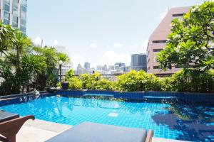 a swimming pool with a city skyline in the background at The Siam Heritage Hotel in Bangkok