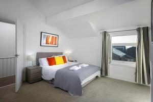 a white bedroom with a bed and a window at Lytham Place in Blackpool