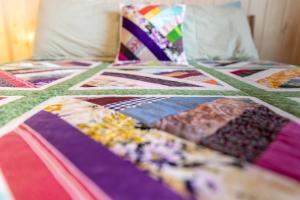 a bed with a colorful quilt on it at Petals oceanview villa 