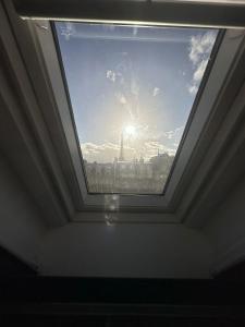 ein Dachfenster in einem Zimmer mit Blick auf den Himmel in der Unterkunft Petit studette sous le toit in the heart of the fashion and luxury district in Paris