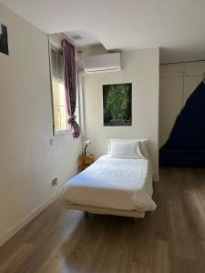 1 dormitorio con cama blanca y ventana en Guest House Éxito en Madrid, en Madrid