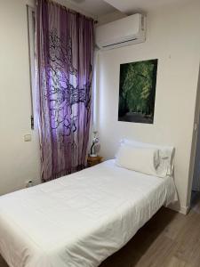 1 dormitorio con cama blanca y cortina púrpura en Guest House Éxito en Madrid, en Madrid