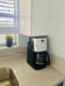 a coffee maker on a kitchen counter next to a sink at One bedroom apt with private patio near Fort Lauderdale beach in Fort Lauderdale