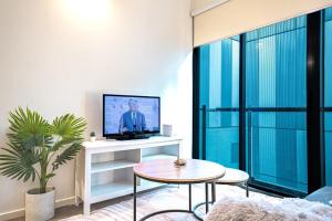 een woonkamer met een tv en een tafel bij Bourke St Mall 1br Studio Convenient Cosy Quiet in Melbourne