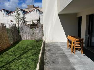 eine kleine Terrasse mit einem Holztisch und einem kleinen Hof in der Unterkunft Apartment close to Paris and métro in Le Pré-Saint-Gervais
