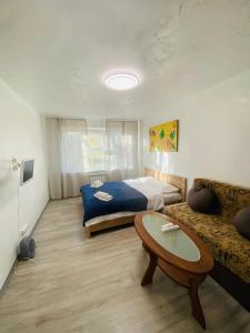 キーウにあるReal Home Apartments- Geroiv Dnipra Metro Stationのベッドルーム1室(ベッド1台、ソファ、テーブル付)