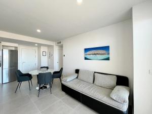 een woonkamer met een bank en een tafel bij Global Properties, Apartamento para 6 personas con terraza in Canet de Berenguer