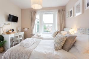 Schlafzimmer mit einem Bett, einem Schreibtisch und einem Fenster in der Unterkunft Harry's House Poole in Poole